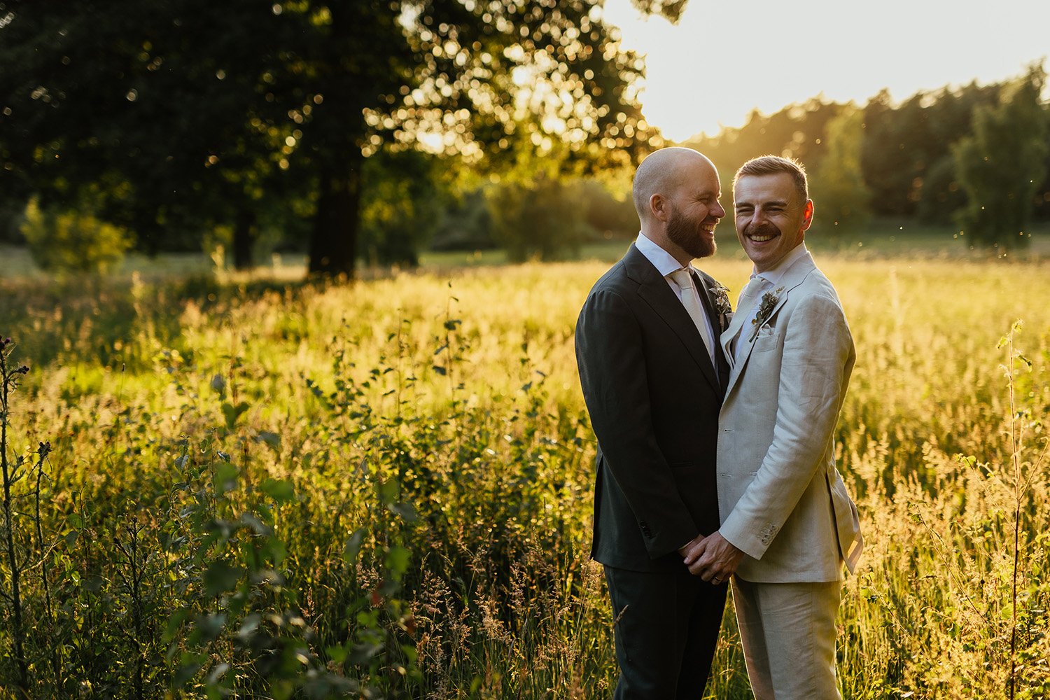 same sex wedding portrait in a field at golden hour